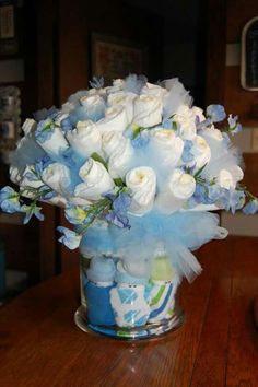 a glass vase filled with white and blue flowers