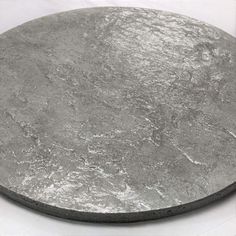 a round metal plate sitting on top of a white table