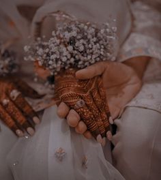 the bride is holding her bouquet of flowers and wearing hendids on her wedding day