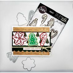 a christmas card with cookie cutters and paper cut outs on top of the card