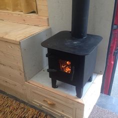 a wood burning stove sitting in the corner of a room