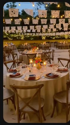 the tables are set with candles and place settings for an outdoor dinner or party event