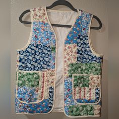 a blue and white vest hanging on a wall next to a hanger with flowers