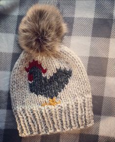 a knitted hat with a pom - pom sitting on top of it