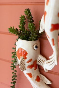 a fish planter hanging on the side of a building