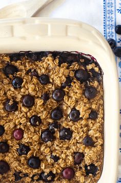 an oatmeal dish with blueberries and granola in it on a table