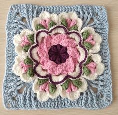 a crocheted square with a flower on it