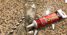 a glass bottle and some toothbrushes on a counter