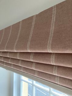 a close up of a roman blind in a window