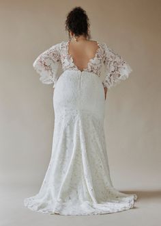 the back of a woman in a white wedding dress, with her hands on her hips