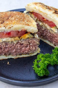 a burger cut in half sitting on top of a black plate