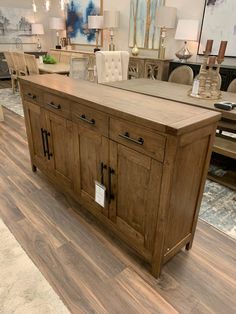 a large wooden cabinet in a store with lots of chairs and lamps on the floor