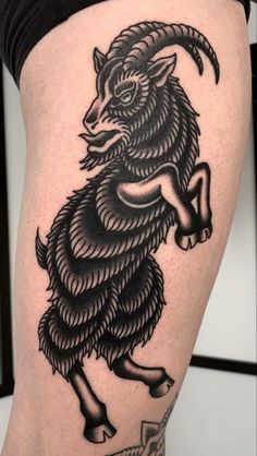 a black and white goat tattoo on the thigh