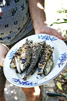 a person holding a plate with fish on it