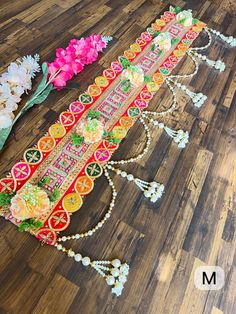 an elaborately decorated table with flowers and beads on the floor in front of it