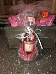 a wine bottle wrapped in plastic and sitting on top of a counter next to some candy