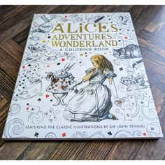 the book alice's adventures in wonderland is sitting on top of a wooden floor