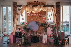 a room filled with lots of furniture next to tall windows and lights hanging from the ceiling