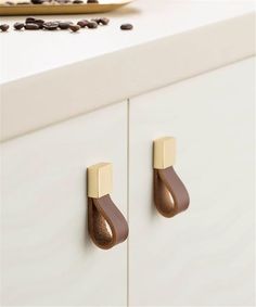 two brown handles on white cabinets with coffee beans