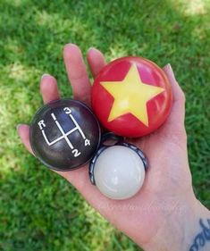 a person holding two balls in their hand and one with a star on it's head