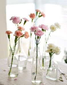 several vases with flowers in them sitting on a table