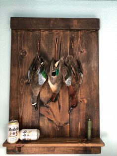 two ducks are hanging on a wooden wall