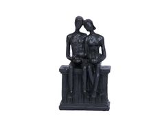 a statue of two people sitting on a bench