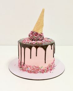 a birthday cake with sprinkles and an ice cream cone on the top