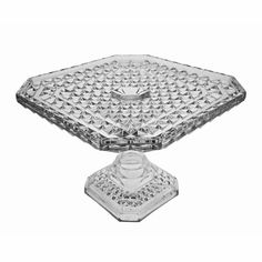 a clear glass cake plate sitting on top of a table