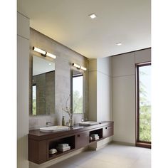 a large bathroom with two sinks and mirrors