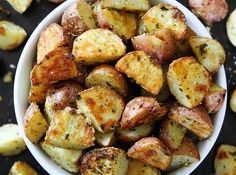 a white bowl filled with potatoes on top of a table