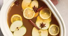 a bowl filled with apple cider and sliced apples