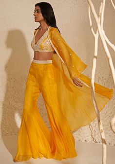 Featuring a fashionable yellow jacket crafted from organza base, accompanied by a matching crepe blouse adorned with intricate aari embroidery. The ensemble is completed with organza palazzo pants featuring an embroidered belt. Perfect for the haldi or mehendi event, exuding a radiant burst of sunshine and regal elegance. Composition : Jacket, Pants - Organza, Blouse - Crepe Care: Dry Clean Only and Vacuum Storage This product can be customized for sleeves, length of blouse and neckline Delivery : 4-6 weeks as the product is hand crafted. Check Size Guide or choose MySize for free customisation (All Sizes above XL can be made at 15% additional cost) For more information and sizes please contact fabiliciousfashion@gmail.com or visit our Copenhagen studio. About the Designer : Zoon, inspired Organza Jacket, Open Blouse, Padded Blouse, Ready To Wear Saree, Palazzo Set, Indian Wedding Wear, Draped Skirt