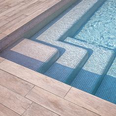 an empty swimming pool with steps leading up to the water's edge and tile flooring