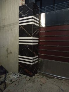 two large black and white marble blocks are next to each other in an unfinished room