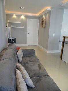 an image of a living room with grey couches and white walls in the background