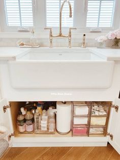 a kitchen sink with drawers underneath it and other items in the bottom drawer under the faucet