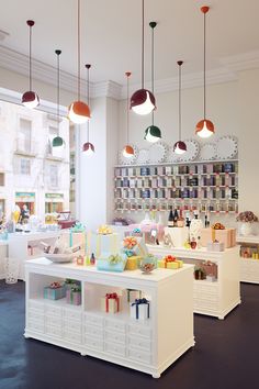 the interior of a store with lots of items on shelves and lights hanging from the ceiling