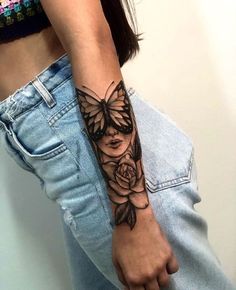 a woman's arm with a butterfly and rose tattoo on the left side of her arm