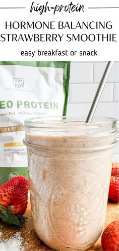 a jar filled with strawberry smoothie next to some strawberries