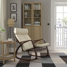 a living room with a rocking chair and bookshelf