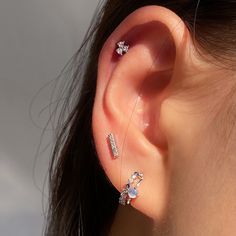 a close up of a person's ear with three piercings