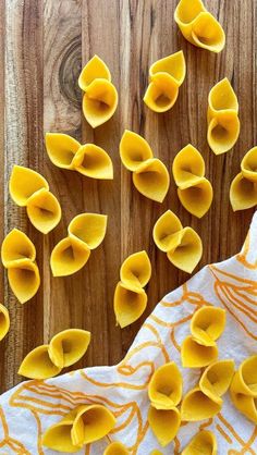 some kind of food that is on top of a wooden table with orange and white napkins