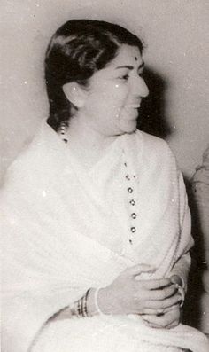 an old black and white photo of a woman smiling