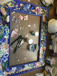 there is a mirror that has been decorated with flowers and other things on it,