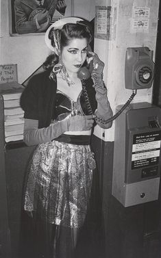 a woman is talking on the telephone while wearing a costume