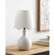 a white lamp sitting on top of a wooden table