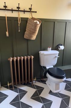 a bathroom with black and white tile flooring next to a wall mounted radiator