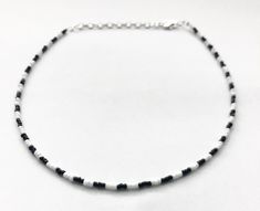 Looking for a sleek, stylish minimalist necklace to add to your everyday collection? Look no further! This awesome black and white necklace is made with Czech glass seed beads and comes with 3 inches of extender chain, making it easily adjustable. The necklace comes in 4 different sizes (14, 16, 18, 20 inches) and comes with extender chain, making the necklace easily adjustable. Perfect for yourself or for someone else, this necklace also makes an amazing gift for lots of different occasions! Minimalist White Choker With Round Beads, Minimalist Black Beaded Necklace, Minimalist White Beaded Choker Necklace, White Choker Necklace, White Bead Necklace, Black And White Necklace, Chip Bead Necklace, Choker Necklace Black, Gold Gemstone Necklace