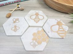 marble coasters with gold bees and honey combs on them, next to books